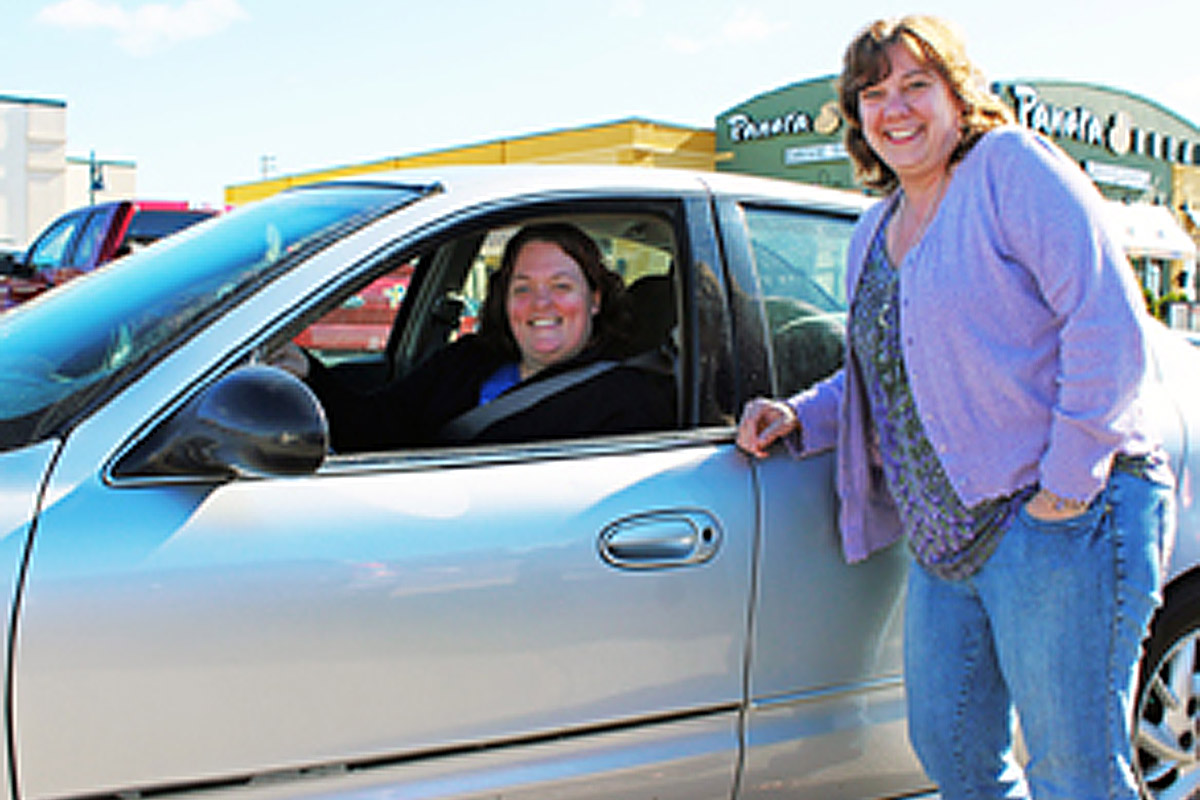 caring member of the community ladies smiling by car