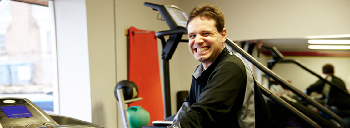 ticket to work guy at gym smiling on treadmill